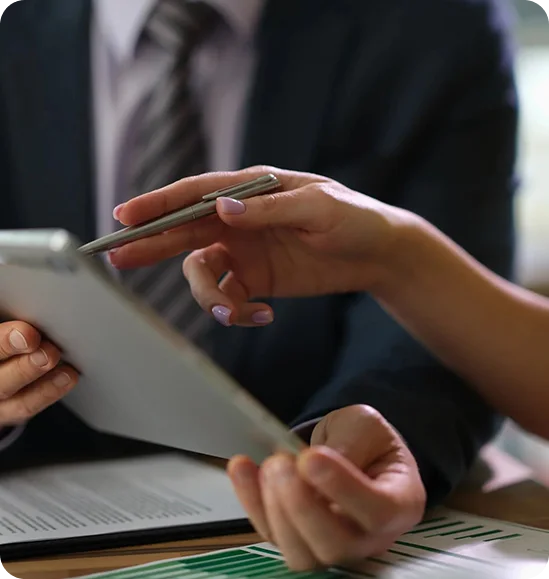 Businesspeople reviewing documents on tablet.